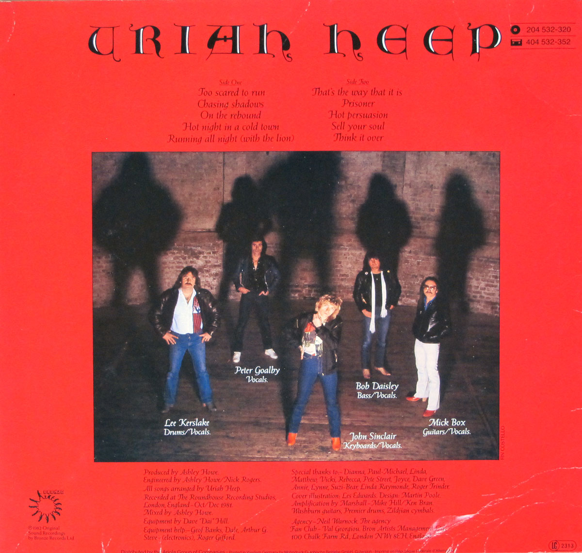 Back cover of Uriah Heep’s Abominog album featuring a red background. The top section displays the band’s name in a gothic font and the tracklist for Side One and Side Two. The lower section shows a group photo of the band members—Lee Kerslake, Peter Goalby, Bob Daisley, John Sinclair, and Mick Box—posing against a brick wall with their shadows dramatically cast behind them. Production credits, acknowledgments, and the Bronze Records logo are included at the bottom